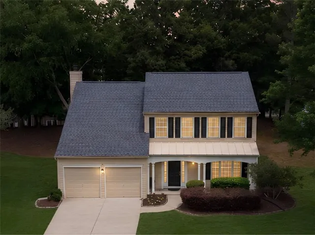 Two-story residence with a covered front porch supported by columns, a two-car garage, and a gabled roof