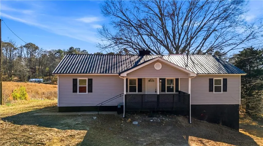 View of front of property featuring a metal roof and a porch