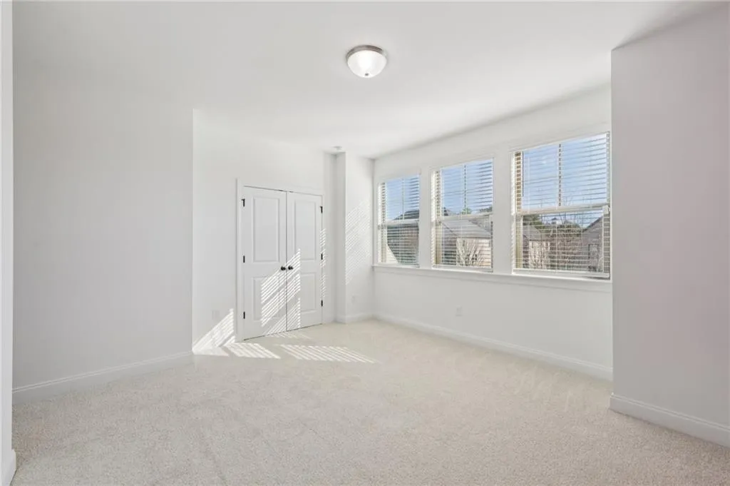 Unfurnished bedroom featuring light colored carpet and a closet