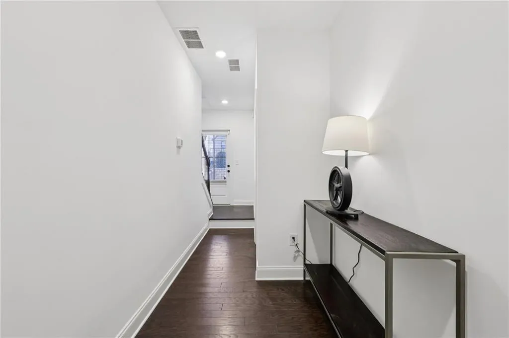 Hall featuring dark wood finished floors and recessed lighting