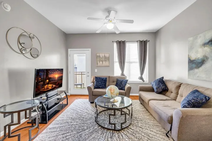 Living area with ceiling fan and wood finished floors