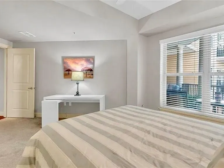 Unfurnished bedroom featuring light carpet and lofted ceiling