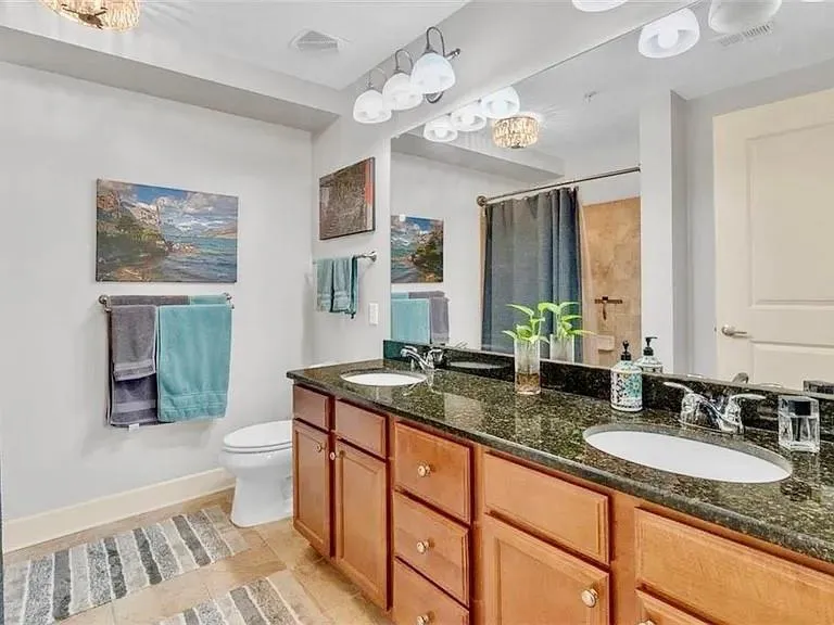 Full bath featuring a chandelier, double vanity, a shower with curtain, and tile patterned flooring