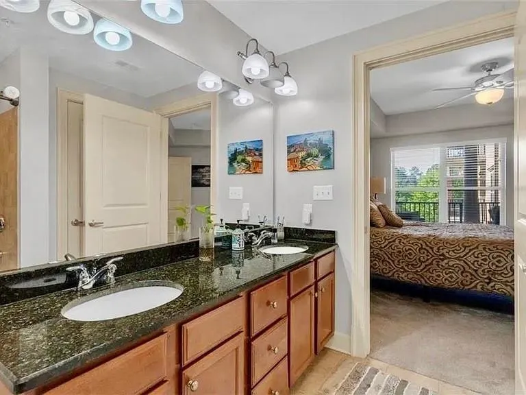 Ensuite bathroom featuring double vanity and a ceiling fan