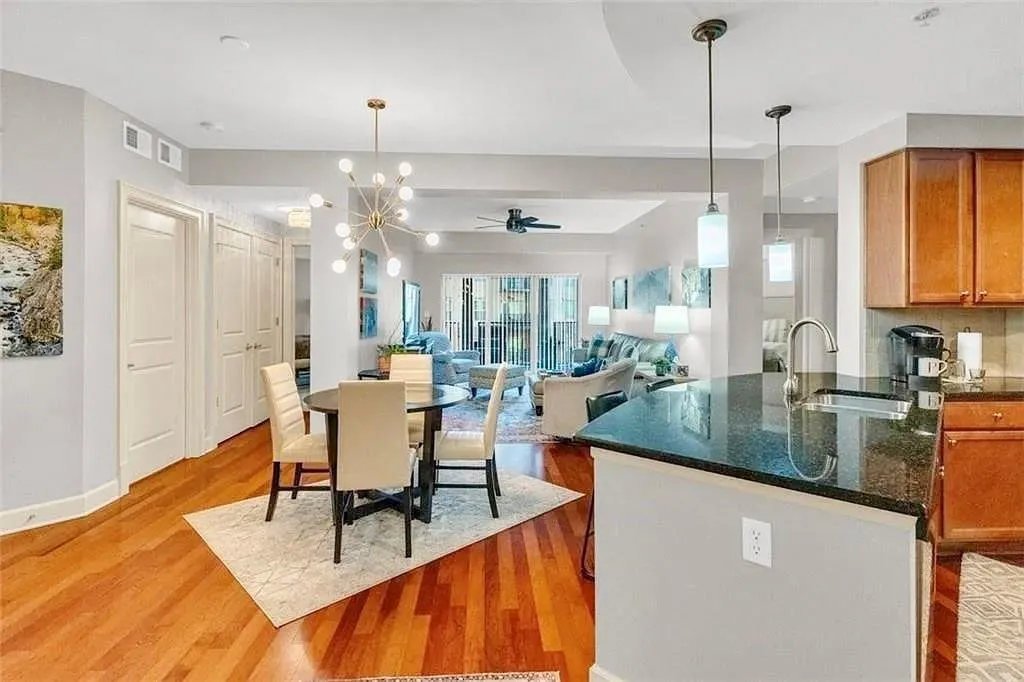Dining room with a ceiling fan, a chandelier, and light wood-style flooring