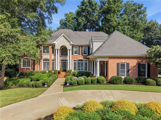 Elegant 4-side brick estate featuring a two-story facade with arched entry