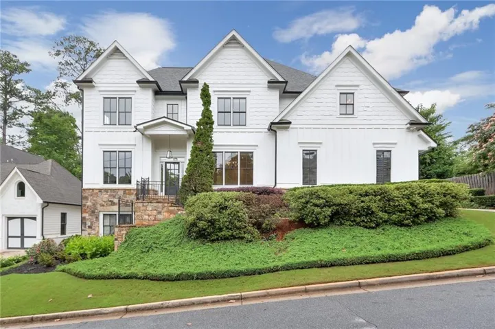 White exterior featuring multiple gables and dark-framed windows