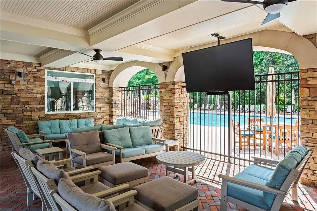 View of patio with outdoor lounge area, a community pool, fence, and ceiling fan