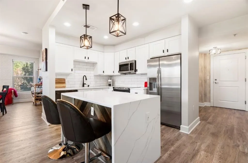 Kitchen featuring light wood finished floors, visible vents, backsplash, and appliances with stainless steel finishes
