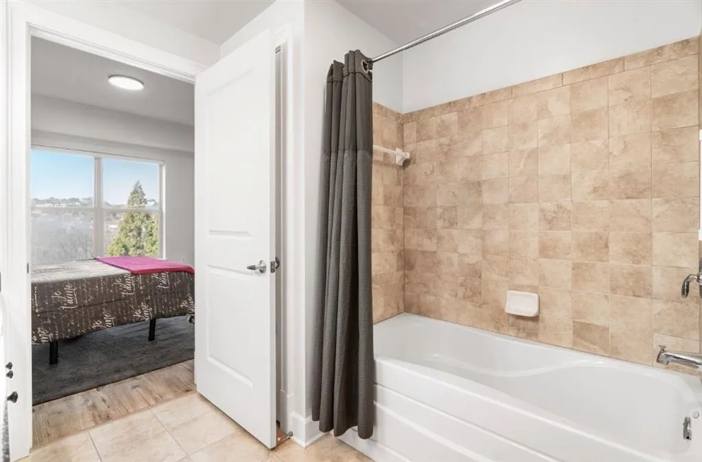 Primary bathroom featuring tile patterned floors and shower / bath combo with shower curtain