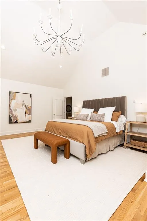 Enormous primary bedroom located upstairs has vaulted ceilings with oversized candelabra chandelier