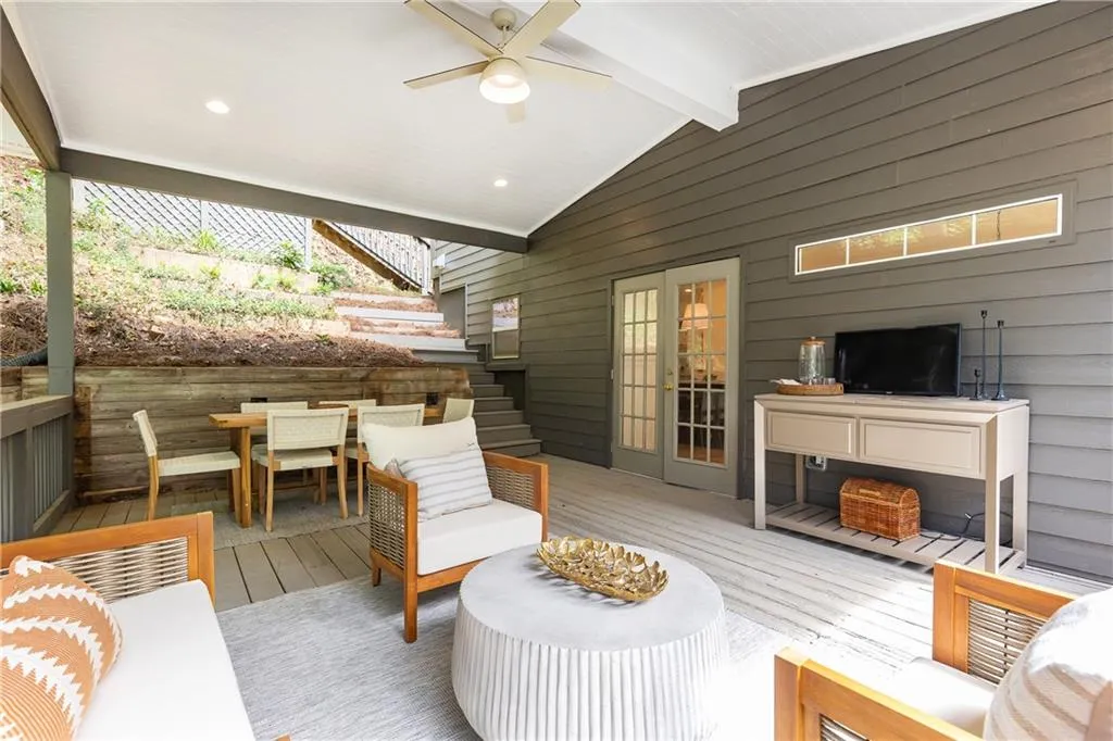 Covered porch with vaulted ceilings, integrated lighting, and ceiling fan