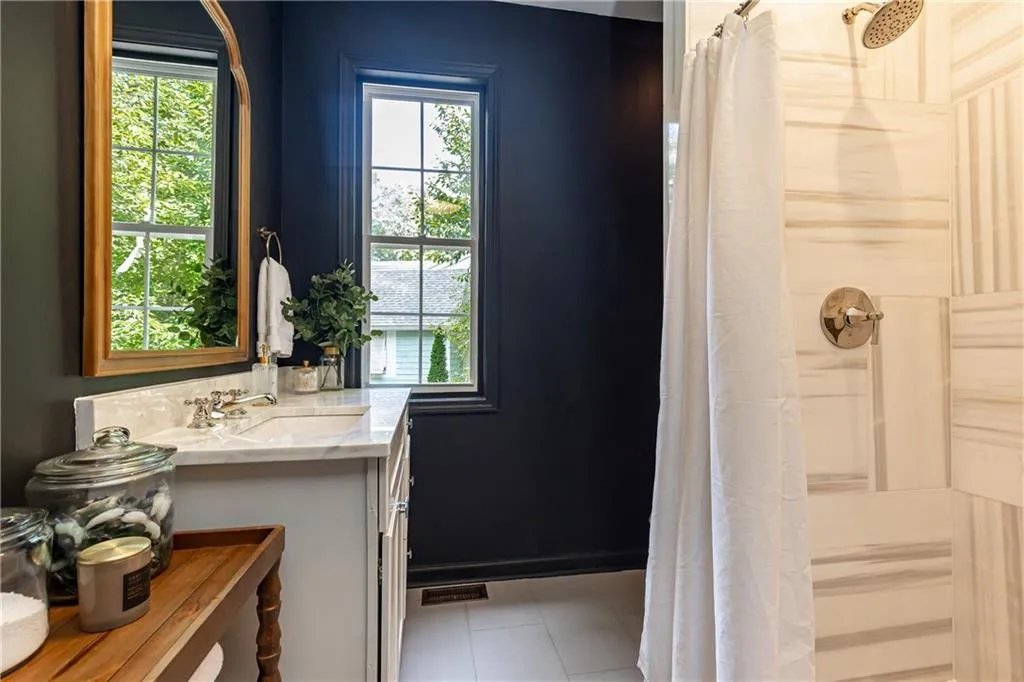 Carraige house lower/guest bath has marble shower and stackable laundry hookups.