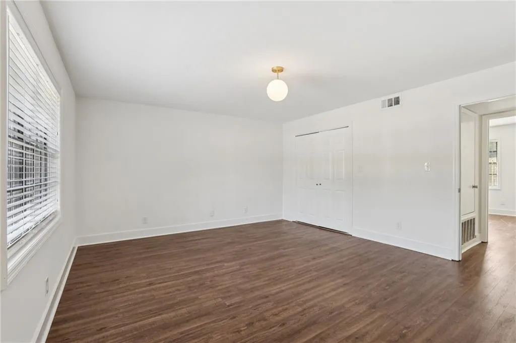 Empty room featuring dark wood-type flooring and baseboards