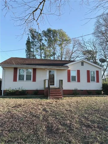 White siding with red shutters and a dark shingle roof