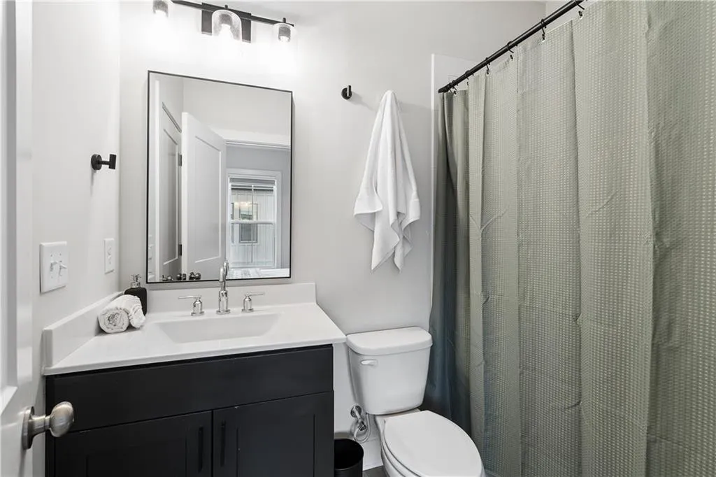 Bathroom featuring a modern vanity with dark cabinetry, white countertop, and rectangular undermount sink