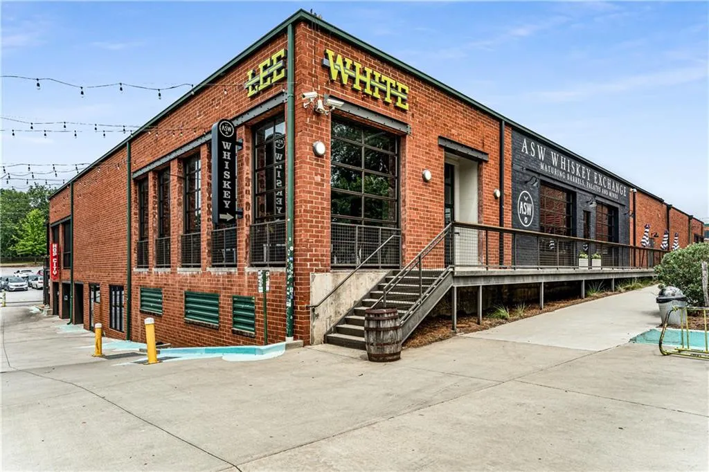 Industrial-style brick building featuring large paneled windows and a metal exterior staircase