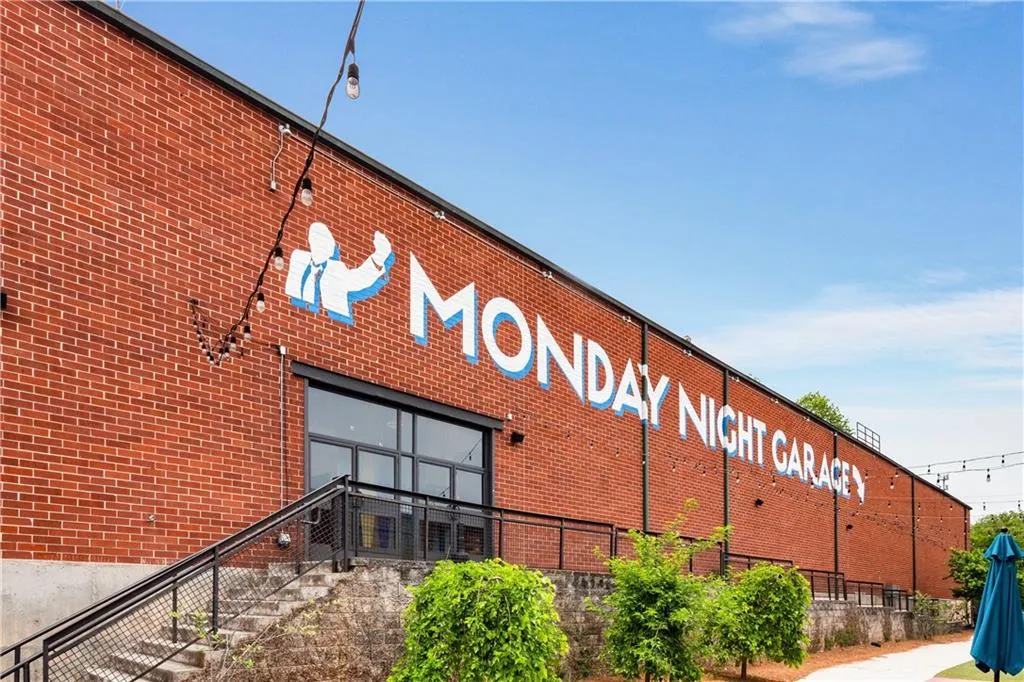 Brick exterior featuring a prominent commercial entrance, string lighting, and an exterior stairway with metal railings