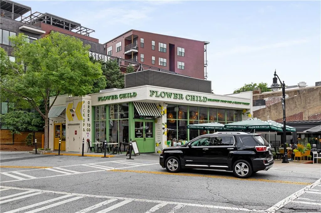 Commercial storefront featuring a bright exterior, large glass windows, and striped awnings