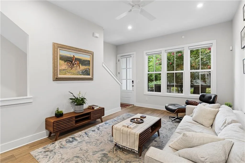 Living room featuring wood-finish flooring and ample natural light from three large windows