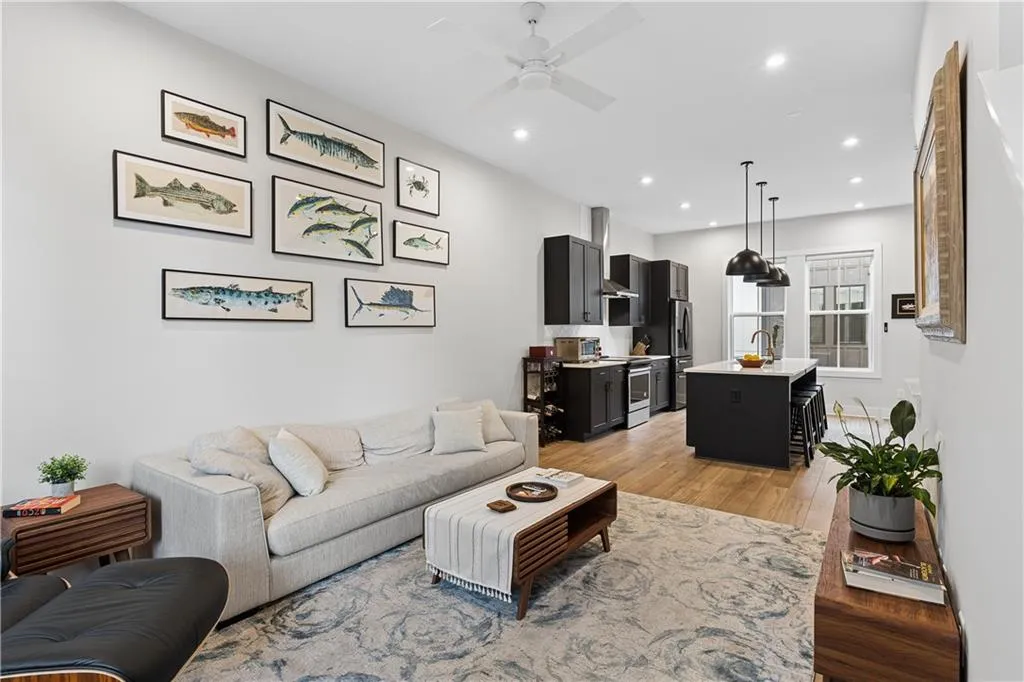 Open-concept living area featuring wood-finish flooring, recessed lighting, and a ceiling fan