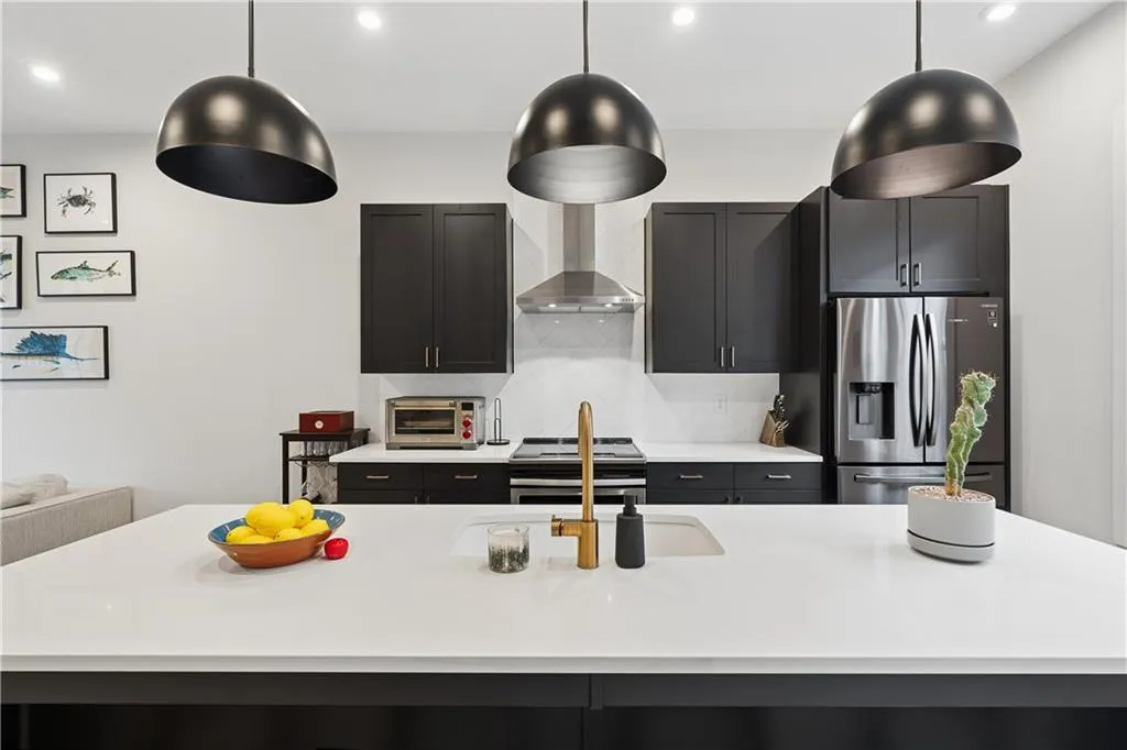 Modern kitchen featuring a large island with an undermount sink and brass-finish faucet