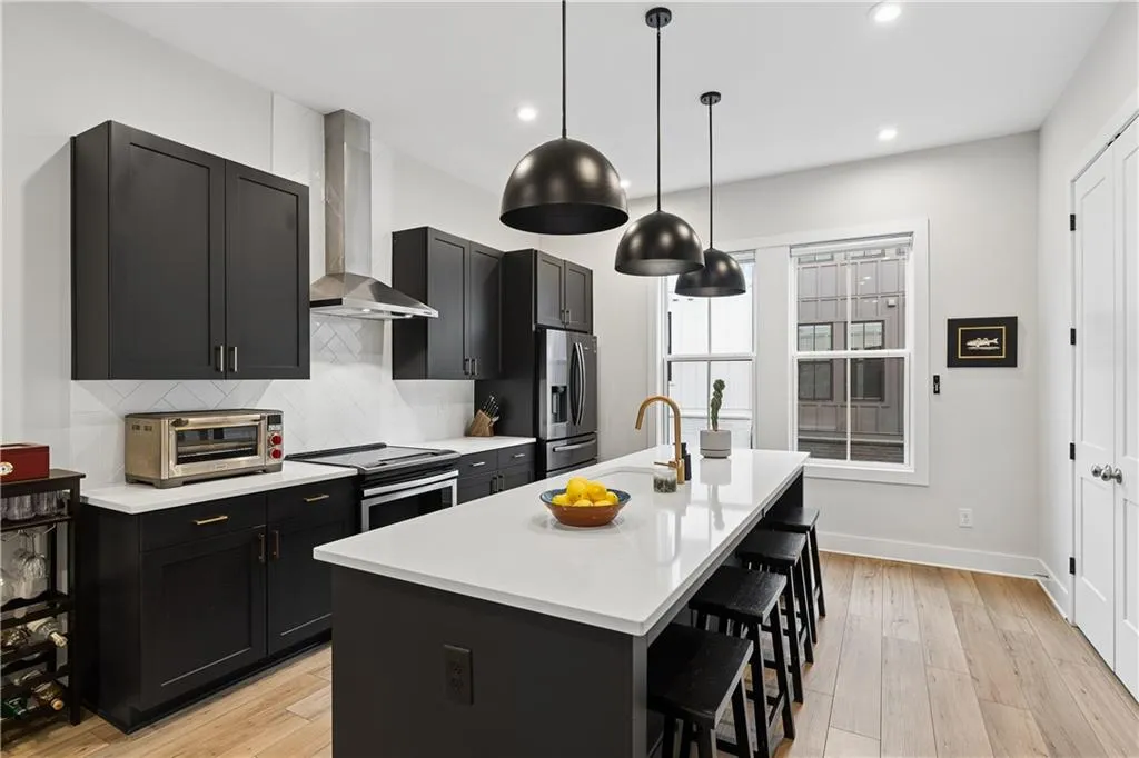 Contemporary kitchen featuring dark wood-finish cabinetry, white countertops, and a white geometric tile backsplash