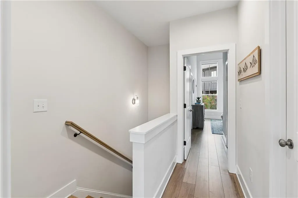 Hardwood-style flooring throughout the upper hallway and visible room