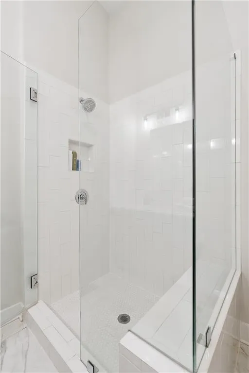 Walk-in shower with clear glass enclosure and chrome hardware