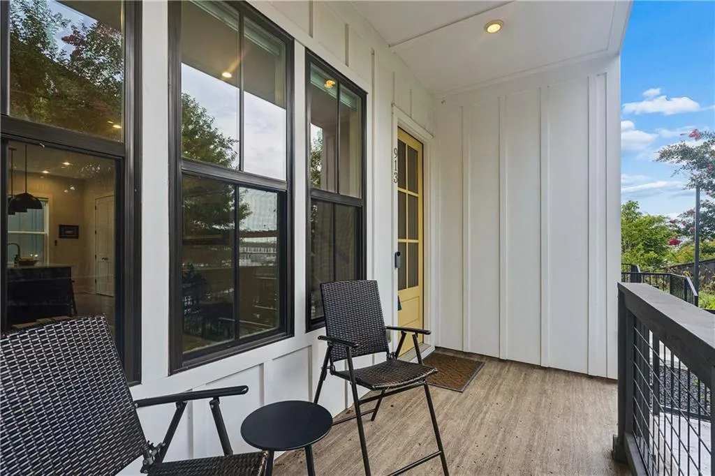 Covered balcony featuring wood-finish flooring and white board-and-batten siding