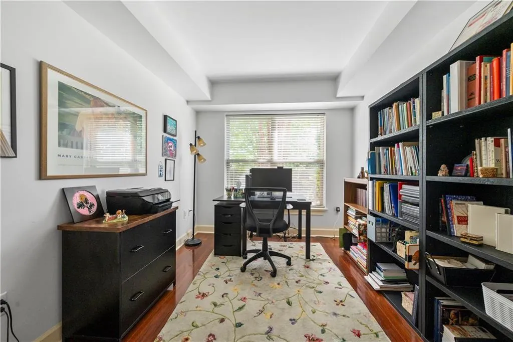Office with dark wood-style floors and baseboards
