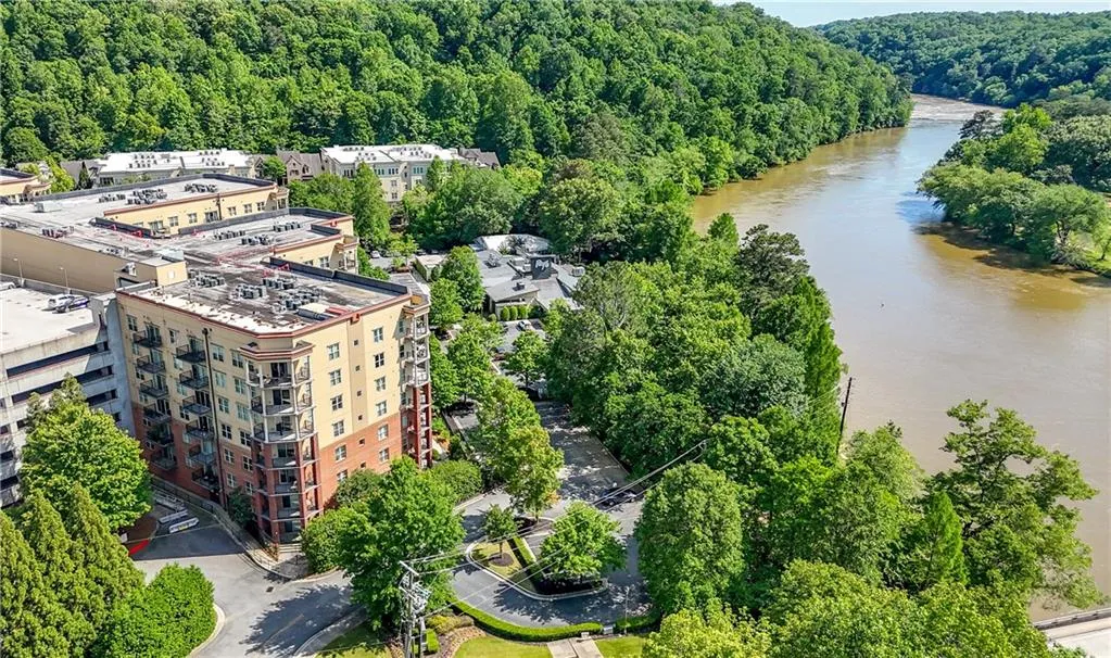Drone / aerial view of a heavily wooded area and a nearby body of water
