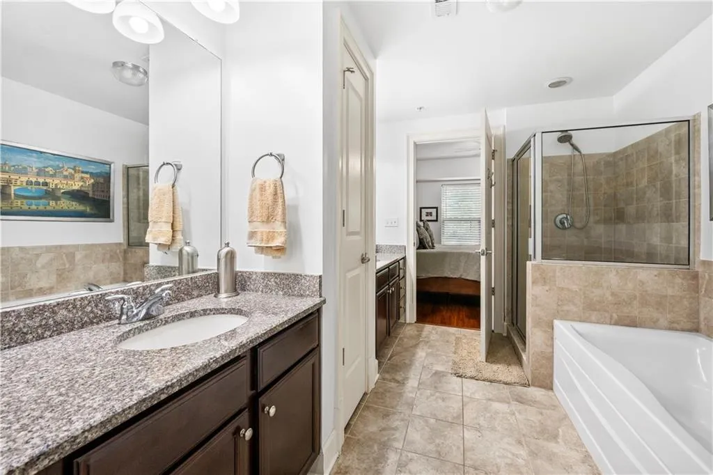 Bathroom featuring ensuite bath, a shower stall, vanity, a garden tub, and tile patterned floors