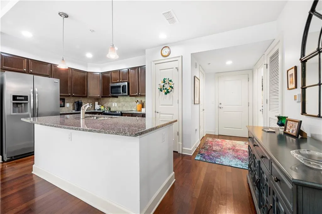 Kitchen with stainless steel appliances, dark brown cabinetry, dark wood finished floors, tasteful backsplash, and recessed lighting
