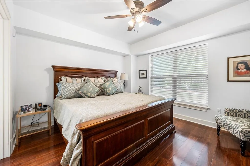 Bedroom with dark wood finished floors, baseboards, and ceiling fan