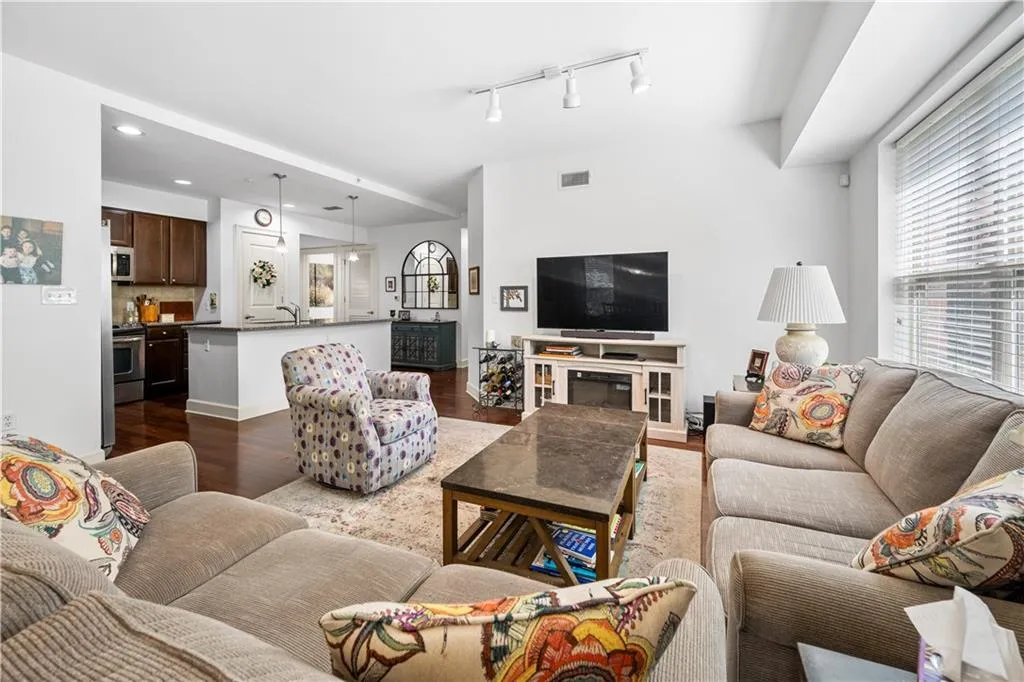 Living room with dark wood-style flooring, rail lighting, and recessed lighting