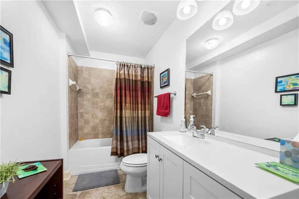 Bathroom featuring toilet, shower / bath combo, and vanity