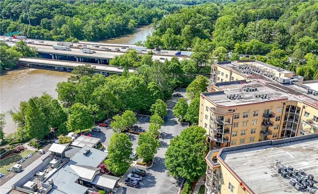 Drone / aerial view of a heavily wooded area and a nearby body of water
