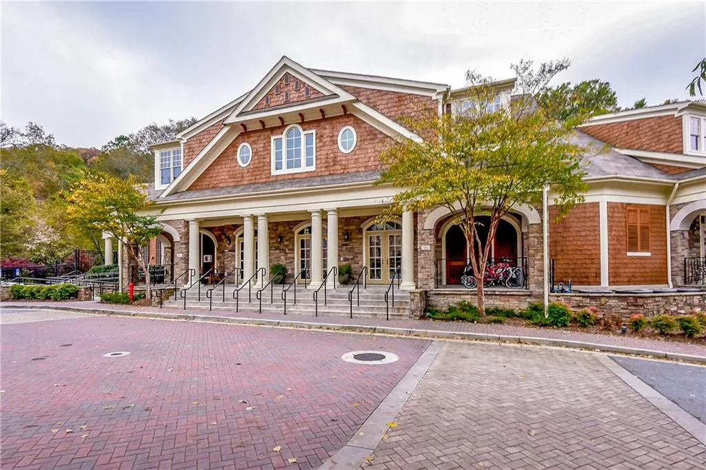View of front of home featuring covered porch, stone siding, and uncovered parking