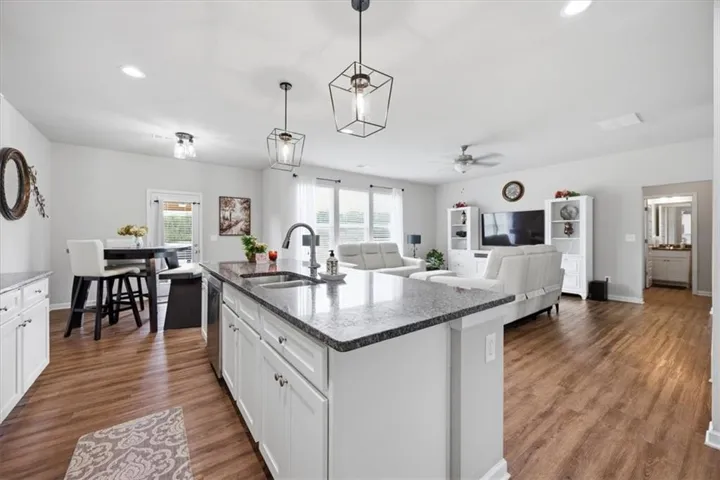 Kitchen island with a stainless steel sink and dark granite countertops
