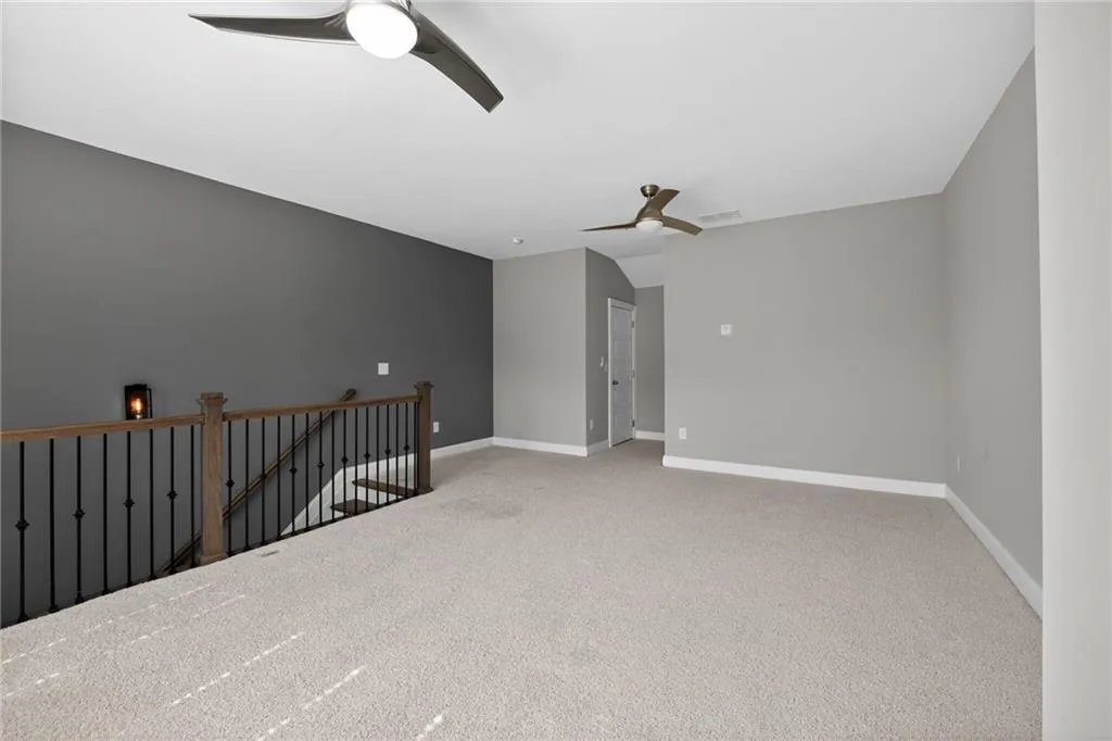 Empty room featuring light carpet and a ceiling fan