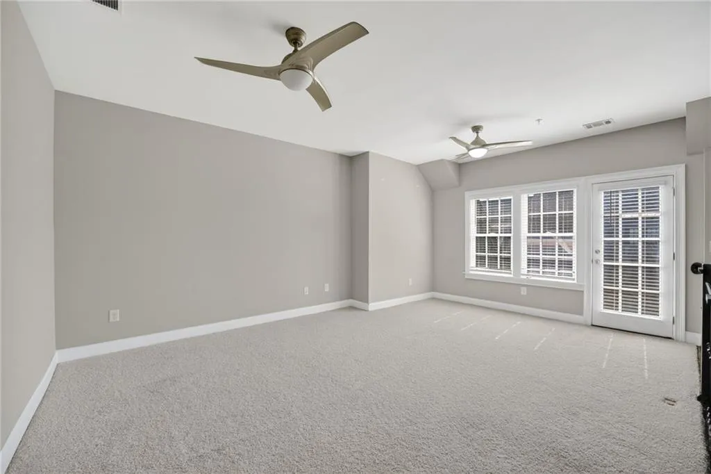 Unfurnished room featuring a ceiling fan and light carpet