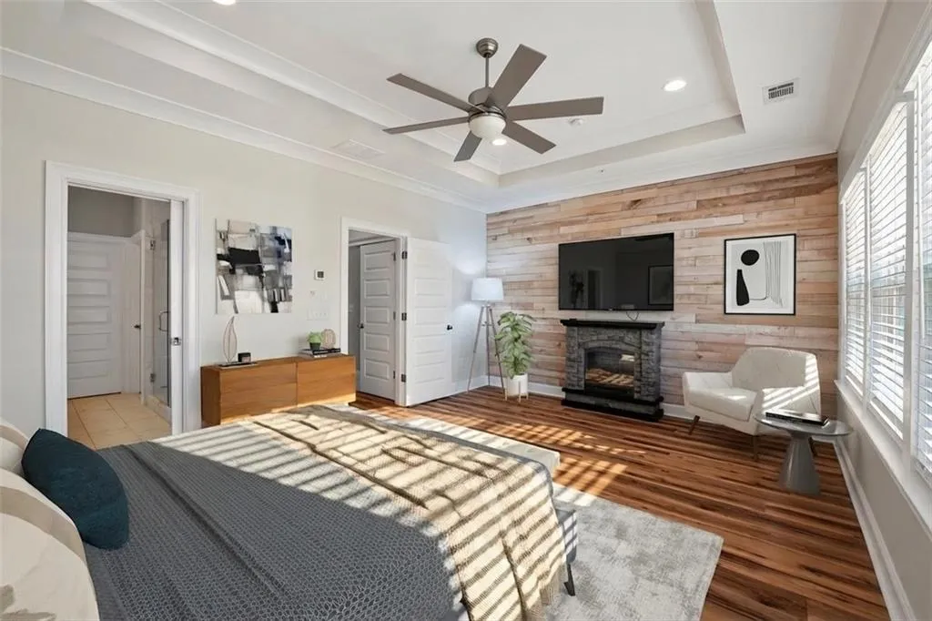 Bedroom featuring wood walls, a stone fireplace, recessed lighting, crown molding, and wood finished floors