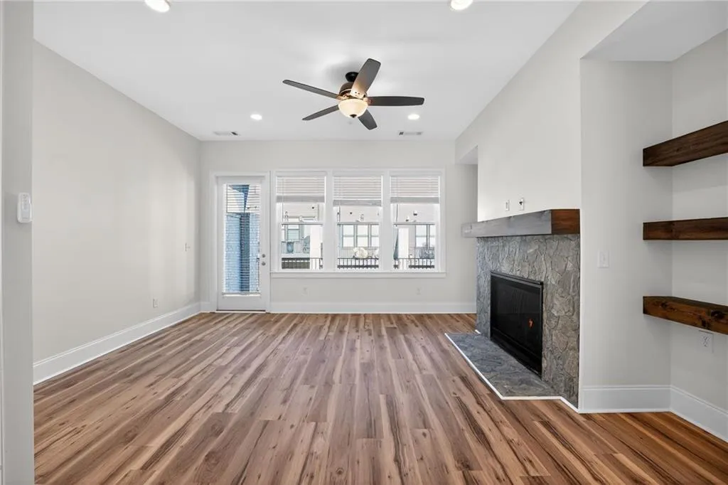 Unfurnished living room with a fireplace, ceiling fan, dark wood-style flooring, and recessed lighting