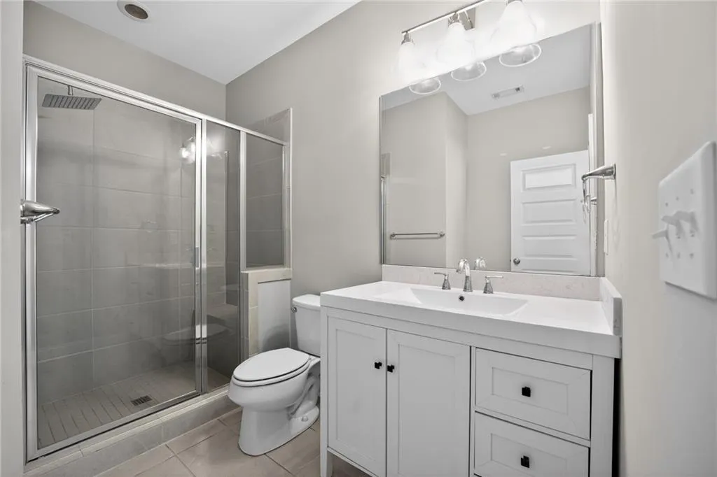 Full bath featuring vanity, a shower stall, and light tile patterned floors