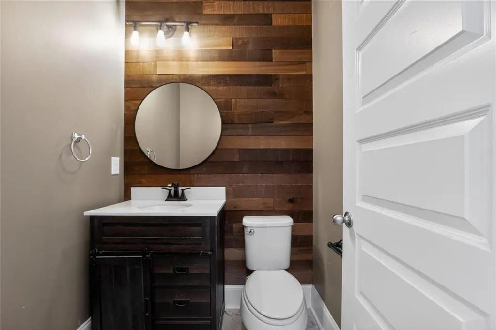 Half bathroom with wood walls and vanity