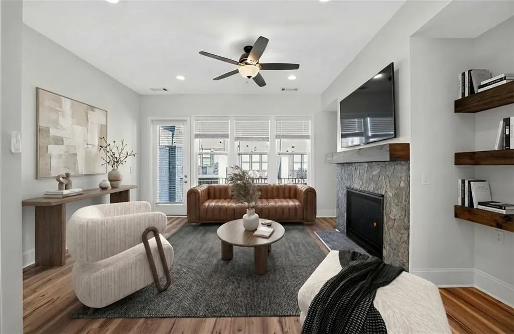 Living area featuring a fireplace, ceiling fan, wood finished floors, and recessed lighting