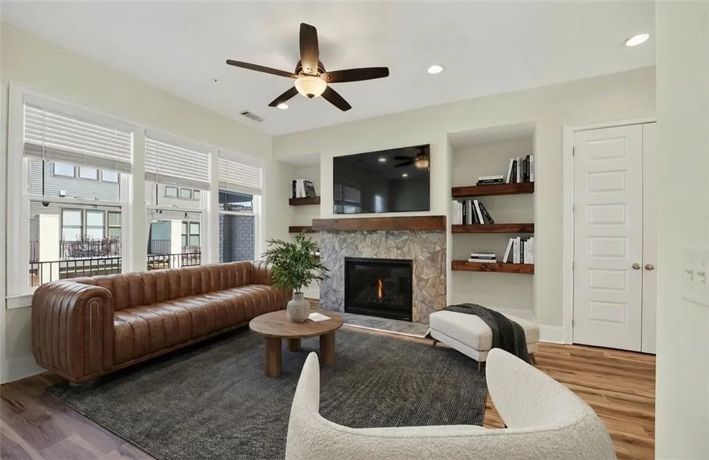 Living room featuring a fireplace, wood finished floors, a ceiling fan, and recessed lighting