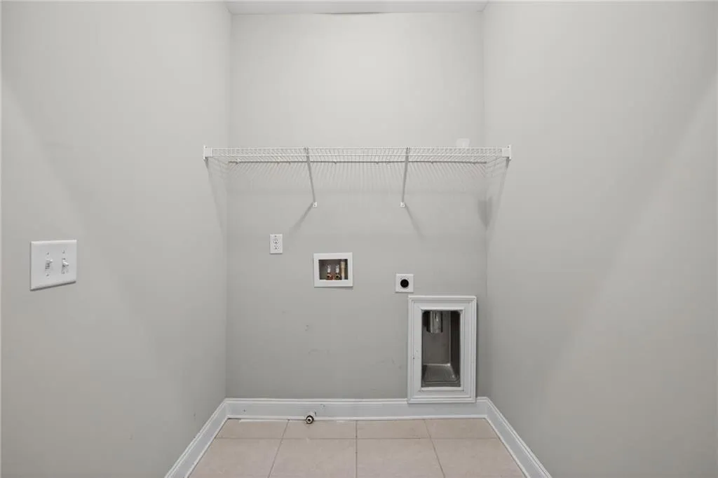 Laundry room with light tile patterned floors, washer hookup, and hookup for an electric dryer