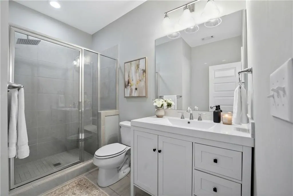 Full bathroom featuring vanity, a shower stall, and light tile patterned flooring